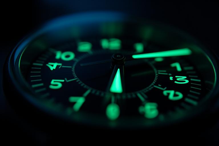 Luminous watch dial glowing in the dark